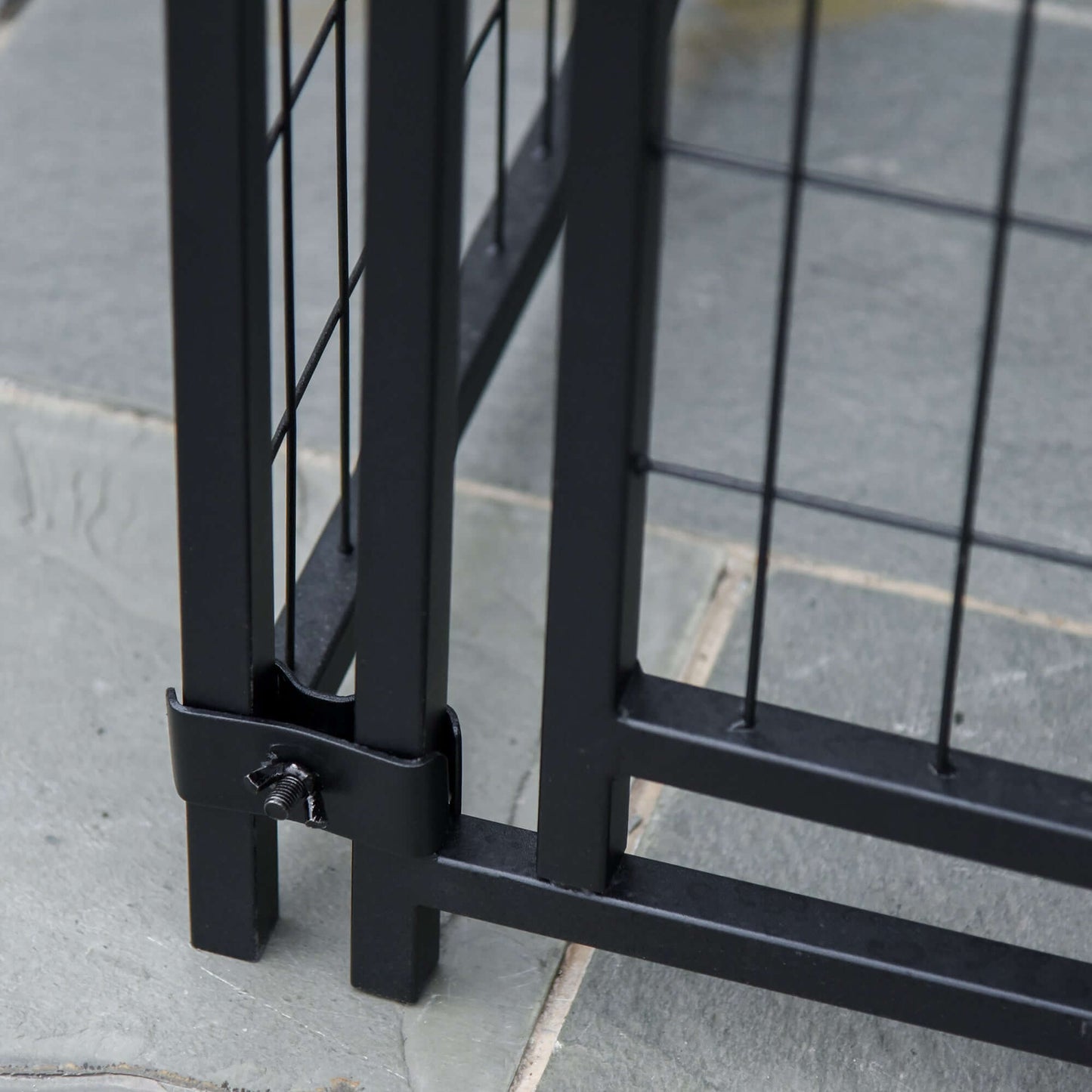 Close-up of the lockable door mechanism on a black steel dog playpen for added security.