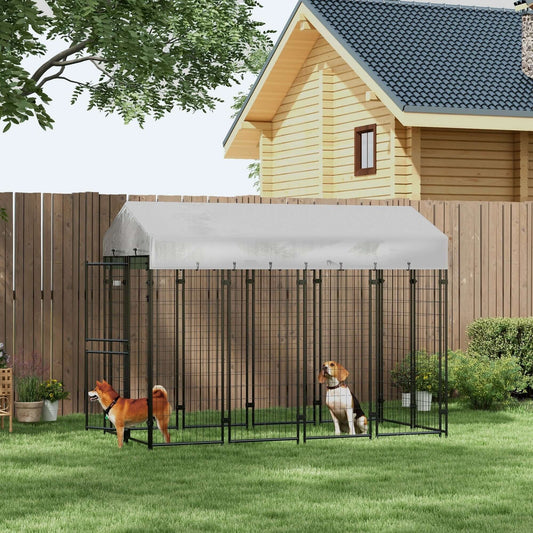 Large silver dog kennel with waterproof cover and two part door design in backyard.